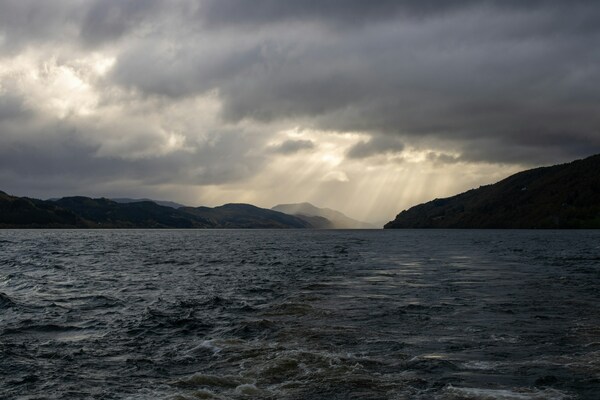 Sun rays beaming through clouds over Loch Ness