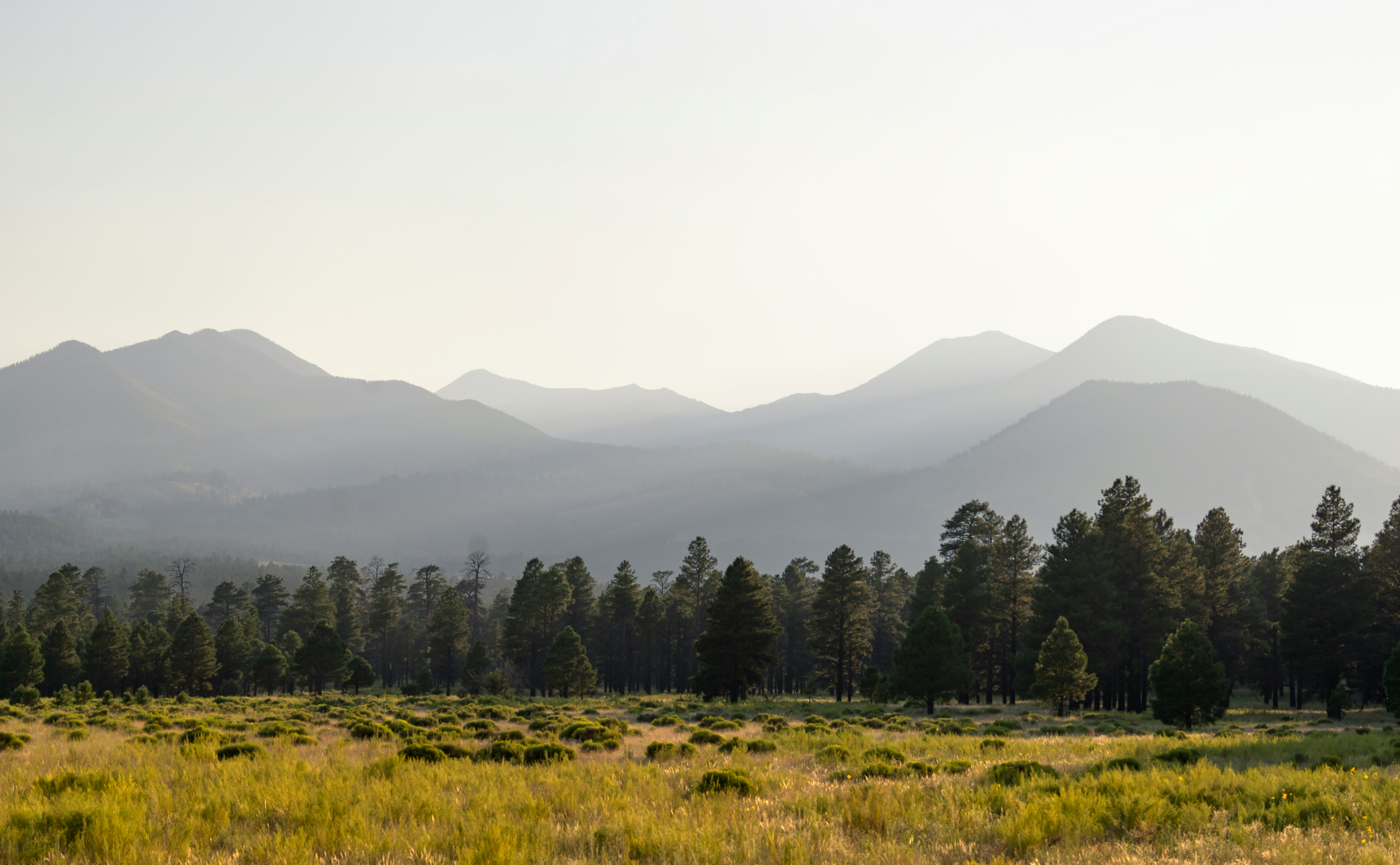 The view of Flagstaff's San Francisco Peaks is veiled by smoke from a forest fire at sunset.