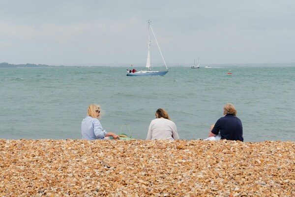 Three friends enjoy the view of the Solent on a Sunday.