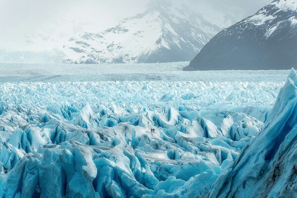 2 people hike on a glacier in Patagonia. El Calafate, Santa Cruz Province, Argentina