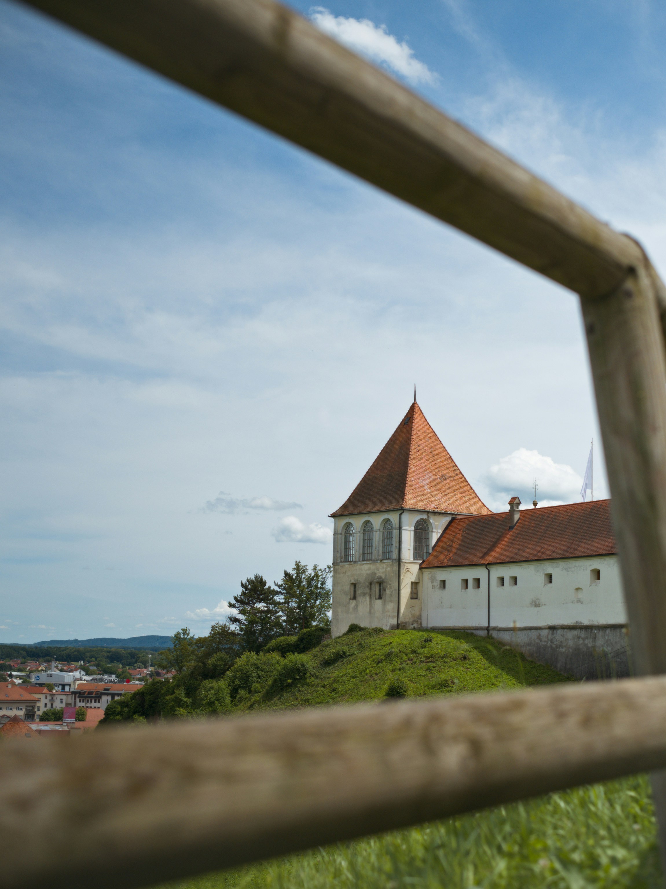 Ptuj castle through a fence with a vista
