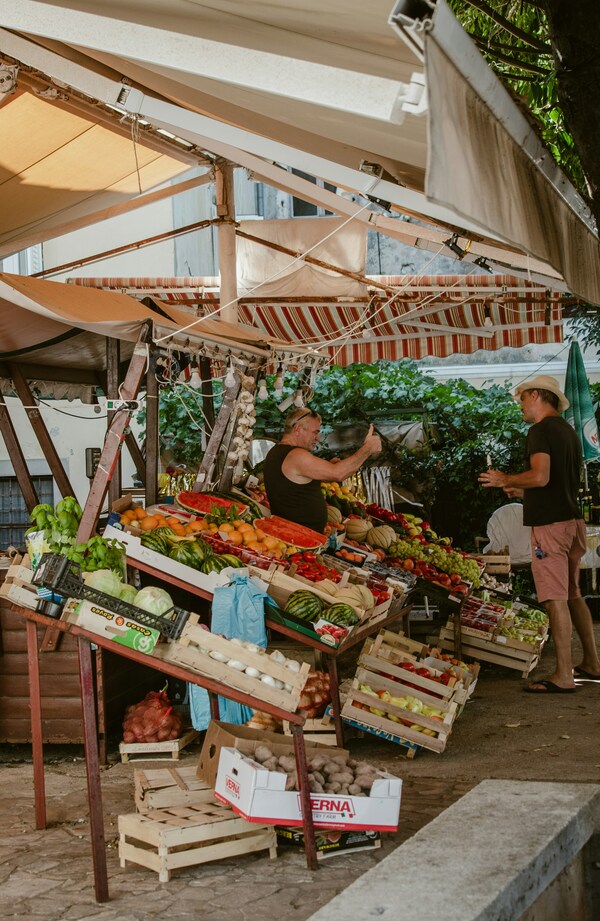 Seller on the fruit market talking to a customer. Mali Losinj, Croatia